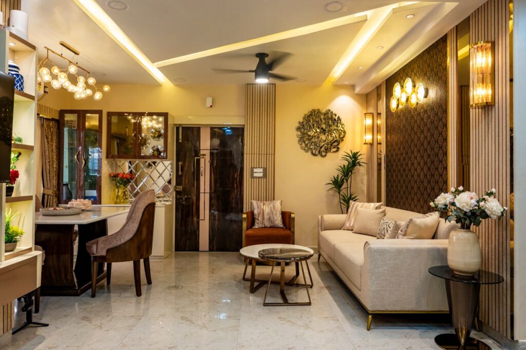 Luxurious living room with modern decor, beige sofa, marble flooring, and elegant lighting.