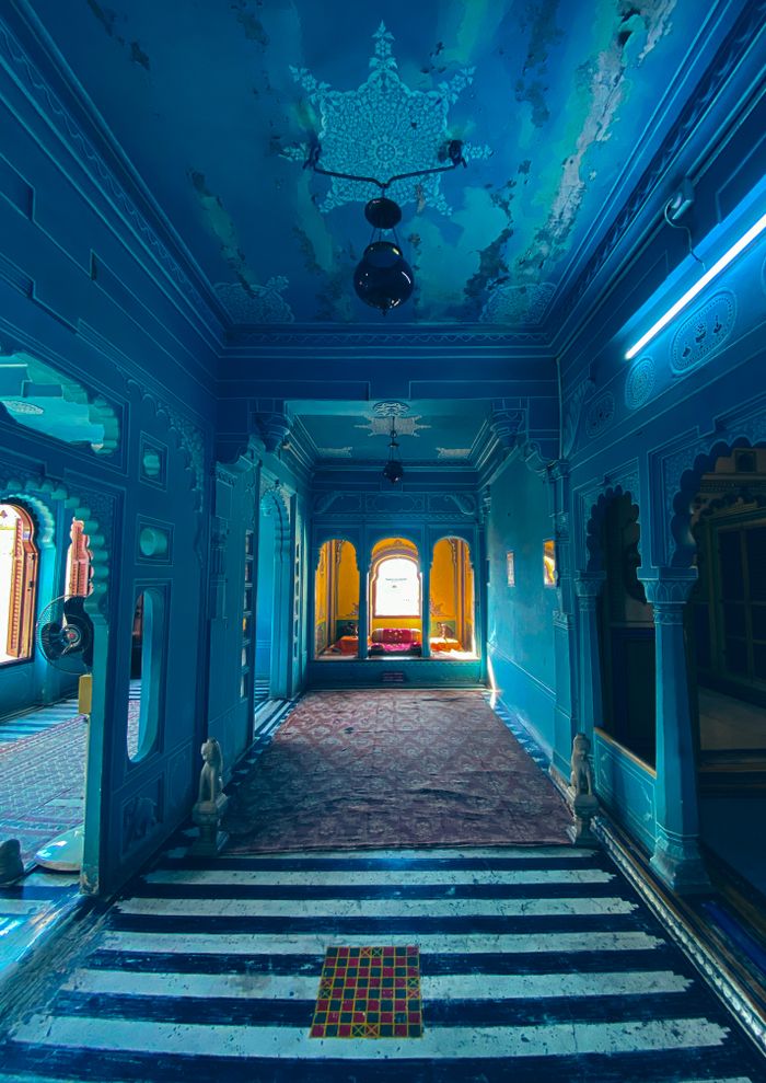 A vibrant blue interior showcasing ornate design, arches, and cultural aesthetics.